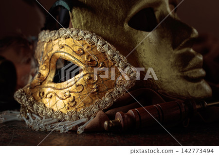 Golden carnival masks on a brown background. 142773494