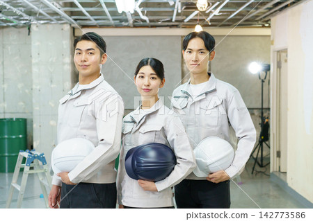 Portraits of young Japanese men and women standing at a construction site. Portraits of young Japanese men and women standing at a construction site. 142773586