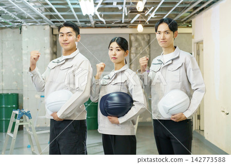 Portraits of young Japanese men and women standing at a construction site. Portraits of young Japanese men and women standing at a construction site. 142773588
