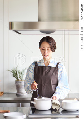 烹調在廚房裡的婦女 烹調在廚房裡的婦女 142773686