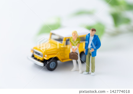 一輛汽車和一個年輕夫婦的玩偶 一輛汽車和一個年輕夫婦的玩偶 142774018
