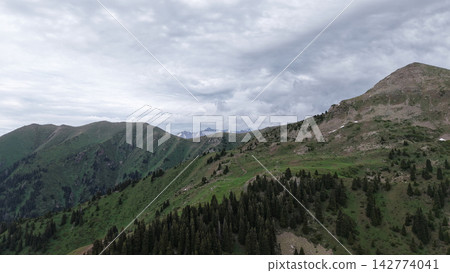 Scenic mountain landscape with green hills and cloudy sky in background Scenic mountain landscape with green hills and cloudy sky in background 142774041