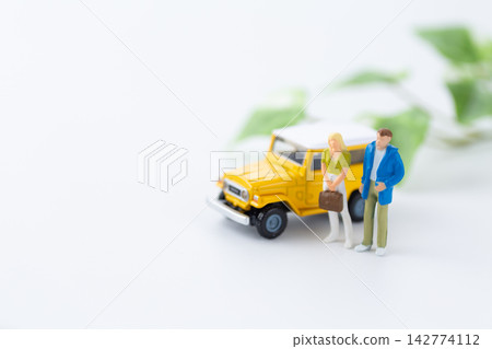 一輛汽車和一個年輕夫婦的玩偶 一輛汽車和一個年輕夫婦的玩偶 142774112
