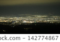 Nighttime cityscape view from mountain overlooking illuminated skyline Nighttime cityscape view from mountain overlooking illuminated skyline 142774867