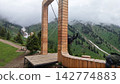 Wooden arch structure in mountainous landscape with cloudy sky Wooden arch structure in mountainous landscape with cloudy sky 142774883