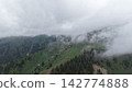 Lush green mountain landscape with fog and clouds in the background Lush green mountain landscape with fog and clouds in the background 142774888