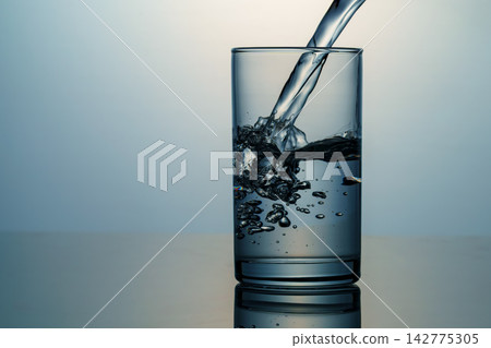 Clear water and bubbles poured into a glass Clear water and bubbles poured into a glass 142775305