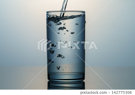 Clear water and bubbles poured into a glass Clear water and bubbles poured into a glass 142775306