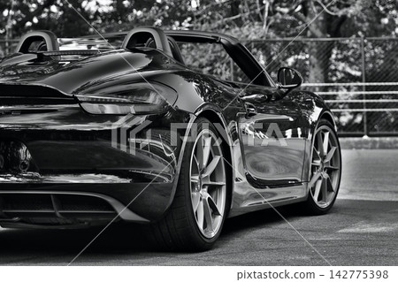 A black Porsche 981 Boxster Spyder that reflects the scenery like a mirror. A black Porsche 981 Boxster Spyder that reflects the scenery like a mirror. 142775398
