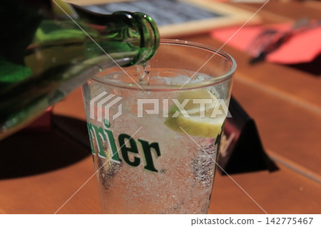 將碳酸飲料倒入杯中。 將碳酸飲料倒入杯中。 142775467