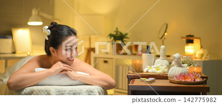 Young woman enjoying relaxing massage therapy at spa, lying on massage table Young woman enjoying relaxing massage therapy at spa, lying on massage table 142775982