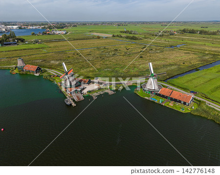 High angle wide horizontal aerial drone photograph of Zaanse Schans historic windmills, river Zaan, timber sawmills, and polder drainage canals in Zaandam, North Holland, Netherlands on sunny day High angle wide horizontal aerial drone photograph of Zaanse Schans historic windmills, river Zaan, timber sawmills, and polder drainage canals in Zaandam, North Holland, Netherlands on sunny day 142776148