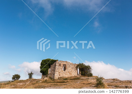 ruins of a house in La Mussara ,Tarragona, Spain, above everything on a hill with a cliff ruins of a house in La Mussara ,Tarragona, Spain, above everything on a hill with a cliff 142776399
