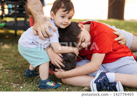 Family brothers bonding with cerebral palsy child Family brothers bonding with cerebral palsy child 142776405