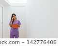 Female doctor talking on the phone holding a patient file 142776406