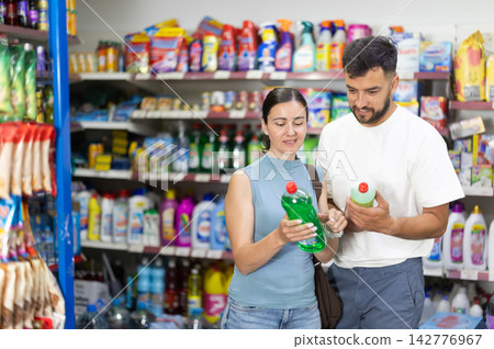 Couple examines product dishwashing detergent in store Couple examines product dishwashing detergent in store 142776967