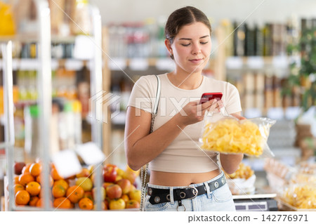 Young woman scanning qr code for chips Young woman scanning qr code for chips 142776971