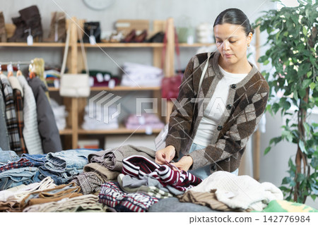 Asian woman browsing goods items and choose elect jumper for autumn Asian woman browsing goods items and choose elect jumper for autumn 142776984