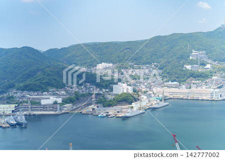 A large cruise ship docks at Nagasaki Port under a blue sky, with the three-dimensional cityscape of Nagasaki in the background. A large cruise ship docks at Nagasaki Port under a blue sky, with the three-dimensional cityscape of Nagasaki in the background. 142777002