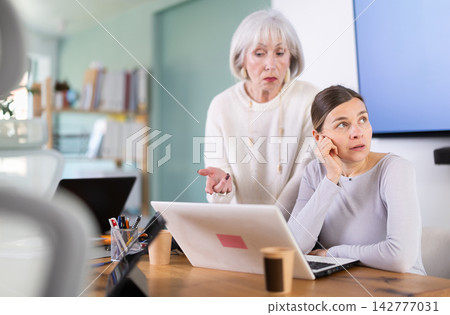 Mature female manager is dissatisfied with the work of an employee - she yells and reproaches her Mature female manager is dissatisfied with the work of an employee - she yells and reproaches her 142777031