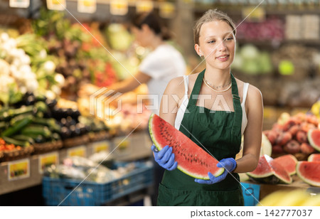 Woman presents fresh watermelon, best option of vegetables from local and imported producers Woman presents fresh watermelon, best option of vegetables from local and imported producers 142777037