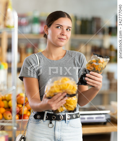 Woman choosing pasta and spaghetti Woman choosing pasta and spaghetti 142777040