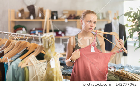Joyful woman choosing tops in store Joyful woman choosing tops in store 142777062