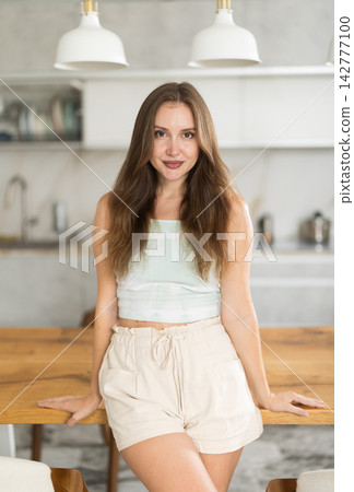 Adult woman in shorts posing in kitchen Adult woman in shorts posing in kitchen 142777100