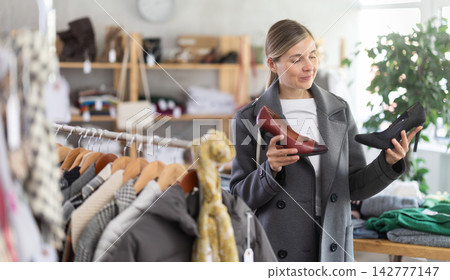 Adult woman choosing high heel shoes in store Adult woman choosing high heel shoes in store 142777147