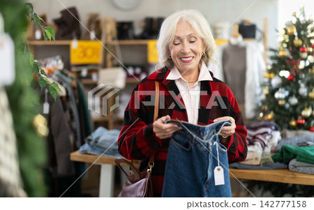 Mature woman choosing jeans in the store Mature woman choosing jeans in the store 142777158