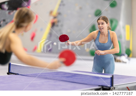 Young girl and her companion are playing table tennis ping pong. Young girl and her companion are playing table tennis ping pong. 142777187