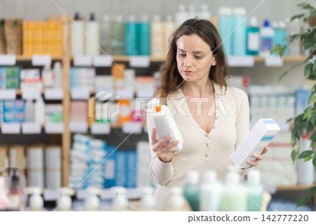 Adult woman chooses cream at pharmacy Adult woman chooses cream at pharmacy 142777220