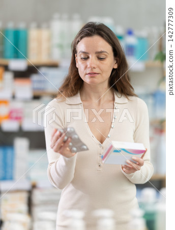 Woman choose pills in pharmacy Woman choose pills in pharmacy 142777309
