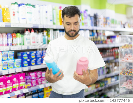Man examines product sun protection cream in store Man examines product sun protection cream in store 142777446