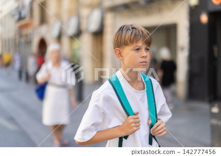 Teenage boy walking along pedestrian street Teenage boy walking along pedestrian street 142777456