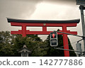 A shrine with a red torii gate and traffic lights. 142777886