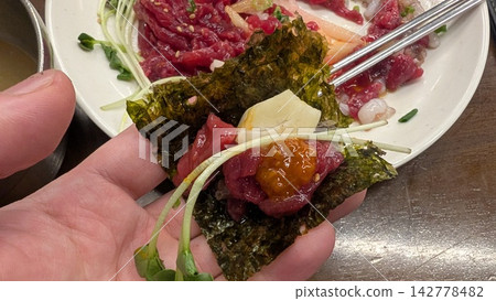一個場景是他們用韓國海苔包裹韓式牛肉韃靼和長臂章魚食用。 一個場景是他們用韓國海苔包裹韓式牛肉韃靼和長臂章魚食用。 142778482