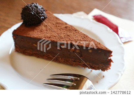 Decadent Slice of Chocolate Cake Dusted with Cocoa Powder Decadent Slice of Chocolate Cake Dusted with Cocoa Powder 142778612