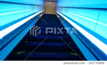 A futuristic space with blue lighting and escalators A futuristic space with blue lighting and escalators 142778866