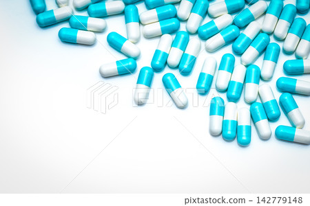 Blue-white antibiotic capsule pills on white background. Colorful capsule pills for healthcare topic. Pharmaceutical industry. Antibiotic drug resistance concept. Antimicrobial drug. Pharmaceutics. Blue-white antibiotic capsule pills on white background. Colorful capsule pills for healthcare topic. Pharmaceutical industry. Antibiotic drug resistance concept. Antimicrobial drug. Pharmaceutics. 142779148