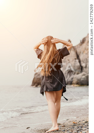 Beach woman hair young woman with long blonde hair on a coastal pebble beach with copy space in the bright sky Beach woman hair young woman with long blonde hair on a coastal pebble beach with copy space in the bright sky 142779269