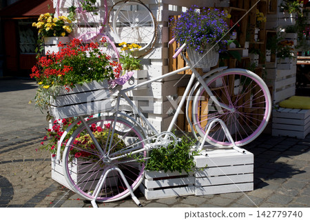 Wroclaw, Poland, June 16, 2018: Decorative white bicycle with colorful flowers at Market Square Wroclaw, Poland, June 16, 2018: Decorative white bicycle with colorful flowers at Market Square 142779740