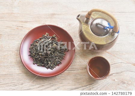 dry Chinese tea leaves with pottery pot and glass on table dry Chinese tea leaves with pottery pot and glass on table 142780179