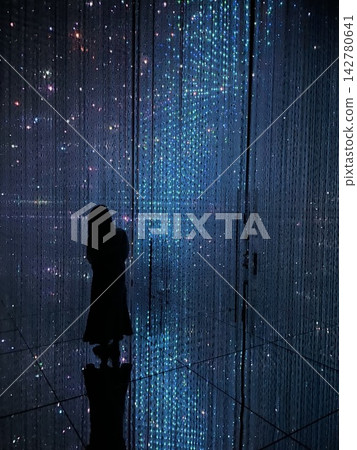 A woman's back as she walks through the illuminations. A woman's back as she walks through the illuminations. 142780641