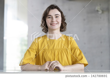 一位年輕的外國女子麵帶微笑,看著鏡頭。 一位年輕的外國女子麵帶微笑,看著鏡頭。 142780691