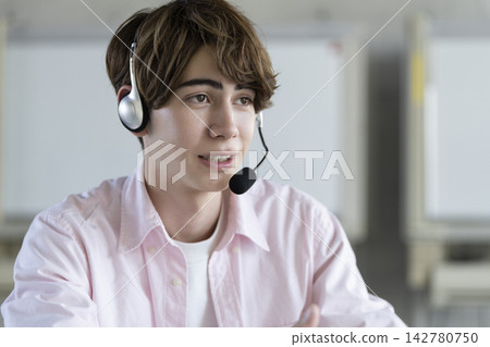 A young foreign man speaking while wearing a headset. A young foreign man speaking while wearing a headset. 142780750