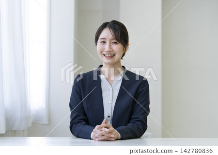 A young businesswoman smiles and looks directly at the camera. A young businesswoman smiles and looks directly at the camera. 142780836