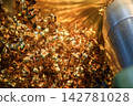 Piles of continuous brass material chips from a turning process on a lathe machine 142781028
