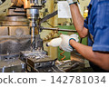 Large hole drilling process on a metal plate with manual coolant feeding on a milling machine 142781034