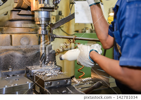 Large hole drilling process on a metal plate with manual coolant feeding on a milling machine Large hole drilling process on a metal plate with manual coolant feeding on a milling machine 142781034